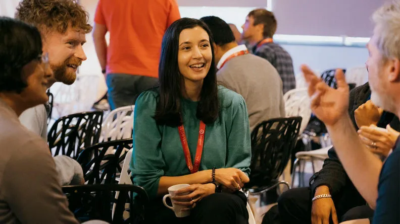 A group of people talking and smiling together.